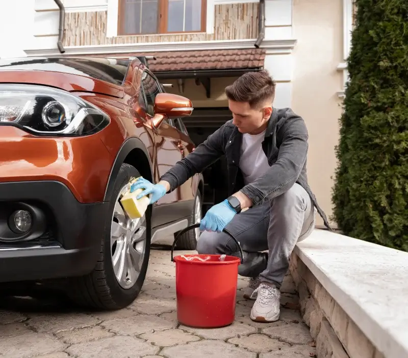 Lavage auto à domicile Neuville-sur-Oise : professionnel intervenant sur un véhicule